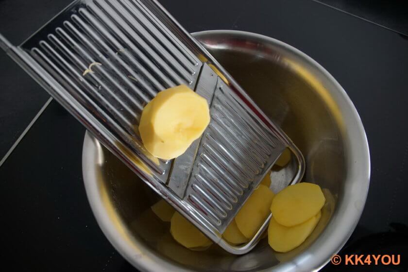 Kartoffeln schälen und in dünne Scheiben schneiden